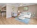 A bright and airy living room features hardwood floors, a white sofa set, and neutral-toned walls at 18702 Van Nuys Cir, Port Charlotte, FL 33948