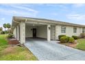 Carport of a single story home with a long driveway and well manicured landscaping at 2214 Highclere Cir # 6, Sun City Center, FL 33573