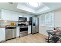 Bright kitchen featuring stainless steel appliances, granite countertops, and white cabinets at 2238 Lark W Cir # D, Palm Harbor, FL 34684