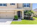 Charming home with a well-manicured lawn, black front door, and two-car garage at 30989 Summer Sun Loop, Wesley Chapel, FL 33545