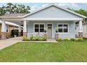 Charming single-story home featuring a inviting front porch and a well-manicured lawn at 311 W Ida St, Tampa, FL 33603