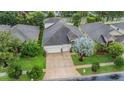 Aerial view of home featuring a well-maintained lawn, mature tree, and a three-car garage at 31331 Anniston Dr, Wesley Chapel, FL 33543