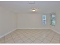 Bright bedroom featuring tile floors, a neutral palette, and well-lit windows at 3209 W Tyson Ave, Tampa, FL 33611