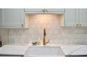 Modern kitchen with a stylish faucet, white countertops, and mosaic tile backsplash at 34 Harbor Oaks Cir, Safety Harbor, FL 34695