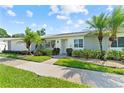Inviting villa featuring lush landscaping, vibrant green lawn and beautiful palm trees at 3410 Stonehaven E Ct # A, Palm Harbor, FL 34684