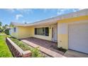 Inviting entrance with brick pathway, yellow accents, and a well-lit walkway to the front door at 4200 49Th S Ave, St Petersburg, FL 33711