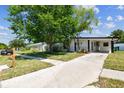Charming single-story home with a covered carport and mature trees in a landscaped front yard at 6551 S West Shore Cir, Tampa, FL 33616
