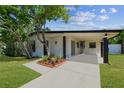 Inviting single-story home with a covered area and vibrant landscaping at 6551 S West Shore Cir, Tampa, FL 33616