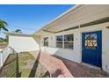 Exterior shot of the front door with brick flooring and a blue door at 709 Pruitt Dr, Madeira Beach, FL 33708
