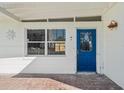 Exterior shot of the front door with brick flooring and a blue door at 709 Pruitt Dr, Madeira Beach, FL 33708