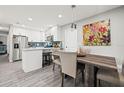 Bright kitchen and dining area boasts stainless appliances, modern backsplash, and wood-look floors at 7307 34Th N Ave, St Petersburg, FL 33710