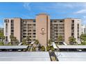 View of The Presidential 7600, a multi-story building with palm trees and covered parking at 7600 Sun Island S Dr # 407, South Pasadena, FL 33707
