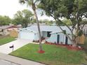 Charming one-story home showcasing a freshly painted exterior, new roof, landscaped yard, and an attached two-car garage at 7831 Red Run Dr, Port Richey, FL 34668