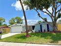 Charming one-story home showcasing a freshly painted exterior, new roof, landscaped yard, and an attached two-car garage at 7831 Red Run Dr, Port Richey, FL 34668