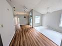 Bright living room featuring a vaulted ceiling, laminate flooring, and natural light at 8209 Volusia Pl, Tampa, FL 33637