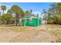 Angle view of charming green house with light roof, complementing lush surroundings at 8215 N 14Th St, Tampa, FL 33604