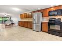 Well-lit kitchen with stainless refrigerator and cherry wood cabinets at 1028 Apollo Beach Blvd # 203, Apollo Beach, FL 33572