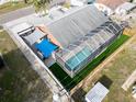 Aerial view of a single Gathering home with a screened-in pool, canopied patio and fenced backyard at 1102 Goshen Rd, Tarpon Springs, FL 34689