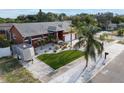 Aerial view of the property showcasing a charming single-story home with manicured lawn and landscaping at 1102 Goshen Rd, Tarpon Springs, FL 34689
