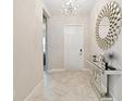 Bright entryway features a modern mirror, tiled floors, and stylish light fixture at 11714 Sunburst Marble Rd, Riverview, FL 33579