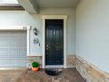 Inviting front entry featuring a stylish black door with decorative stone accents and brick pavers at 11714 Sunburst Marble Rd, Riverview, FL 33579