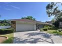 A beautiful single-story home with a brick-paved driveway leading to a two-car garage at 13725 Oak Forest N Blvd, Seminole, FL 33776