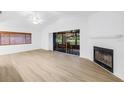 Bright living room with wood floors and fireplace, leading to screened-in porch at 13898 Egret Ln, Clearwater, FL 33762