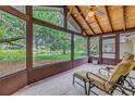 Enclosed porch features a wood plank ceiling and peaceful lake views at 13898 Egret Ln, Clearwater, FL 33762