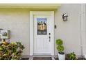 Charming front entrance featuring a decorative door with glass inset, sidelights, and a welcoming monogram at 1676 Arabian Ln, Palm Harbor, FL 34685