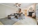 Comfortable living room featuring a large sectional sofa, fireplace, staircase and neutral color palette at 1676 Arabian Ln, Palm Harbor, FL 34685