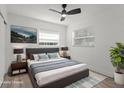 This staged main bedroom features neutral paint, ceiling fan, luxury flooring, and modern lamps at 2112 Ranchita Trl, Holiday, FL 34690