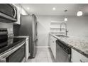 Bright kitchen featuring stainless steel appliances, granite countertops, and white cabinets at 2581 Countryside Blvd # 2309, Clearwater, FL 33761