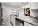 Kitchen boasts granite countertops, stainless steel dishwasher, and modern pendant lighting at 2581 Countryside Blvd # 2309, Clearwater, FL 33761