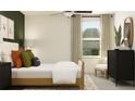Bright bedroom featuring natural light, neutral decor, and black dresser at 2724 Bryce Ravine Ave, Plant City, FL 33563