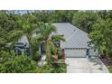 An aerial view of the home showcasing its roof, driveway, landscaping and three car garage at 27440 Cedar Park Ct, Wesley Chapel, FL 33544