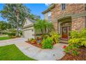Charming home featuring stone accents and colorful landscaping near the front entrance at 3000 Naughton Way, Tarpon Springs, FL 34688