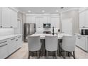 Modern kitchen featuring white cabinets, stainless steel appliances, and a center island with bar seating at 32193 Watoga Loop, Wesley Chapel, FL 33543