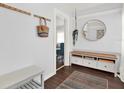 Inviting foyer with dark floors, round mirror, and a storage bench with drawers at 3230 4Th S Ave, St Petersburg, FL 33712