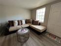 Inviting living room featuring a plush sectional sofa, modern flooring, and a sunlit window at 3625 Windham Dr, Holiday, FL 34691