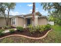Exterior of home featuring a well-manicured lawn, beautiful trees, and a welcoming entrance at 3908 Douglas Hill Pl, Parrish, FL 34219