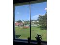 A serene view of a well-manicured lawn and a community pool from inside the home at 4705 Ne 1St Ne St # 327, St Petersburg, FL 33703