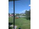 A bright view of a lush green lawn and a sparkling community pool from inside the home at 4705 Ne 1St Ne St # 327, St Petersburg, FL 33703