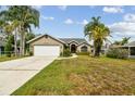 Charming one story home featuring mature trees, a well kept lawn, and an attached two car garage at 5112 Parkway Blvd, Land O Lakes, FL 34639
