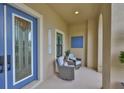 Inviting front porch featuring comfortable seating, a stylish blue door, and a welcoming ambiance at 6016 Shadowlake Dr, Apollo Beach, FL 33572