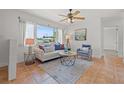 Bright living room with a large window, ceiling fan, neutral paint, and comfortable seating at 715 45Th Ne Ave, St Petersburg, FL 33703