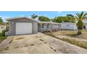 Exterior view of a gray home with a red front door and a large front driveway at 7411 Seashore Dr, Port Richey, FL 34668