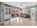 Sunlit living room with wood floors and sliding glass doors to a covered patio at 8220 12Th N Way # G, St Petersburg, FL 33702