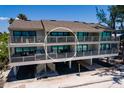 Rear exterior of elevated three-story beach house boasting expansive balconies overlooking the Gulf at 8226 W Gulf Blvd # 2, Treasure Island, FL 33706