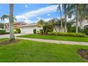 Charming single-story home featuring a three-car garage, well-manicured lawn, and lush tropical landscaping at 9402 Woodbay Dr, Tampa, FL 33626