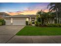 Charming single-story home featuring a three-car garage, well-manicured lawn, and lush tropical landscaping at 9402 Woodbay Dr, Tampa, FL 33626
